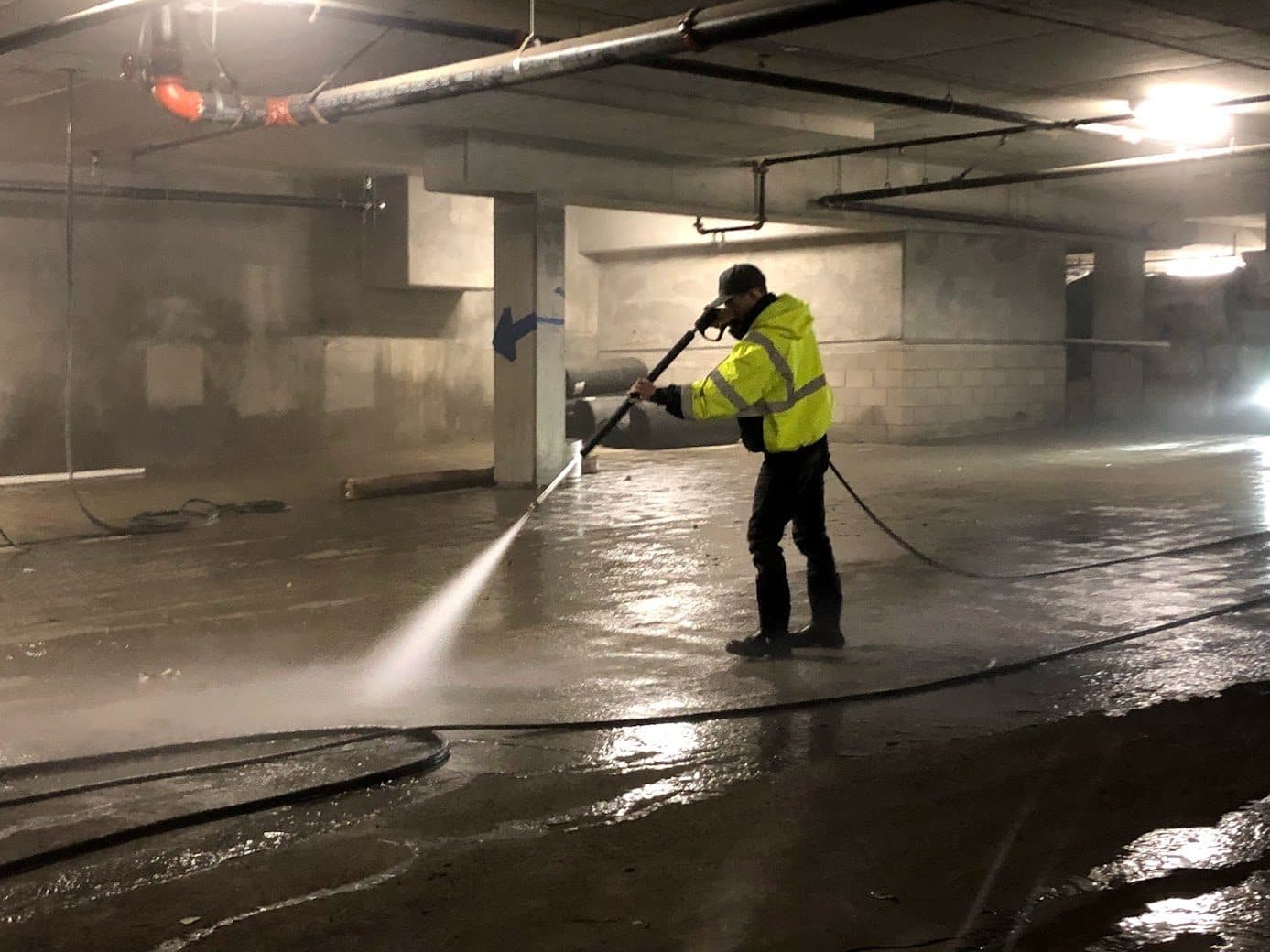 Crew pressure-washing a parking structure